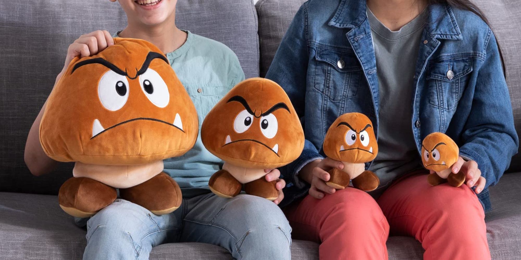 A group of people sitting on a couch holding stuffed animals.