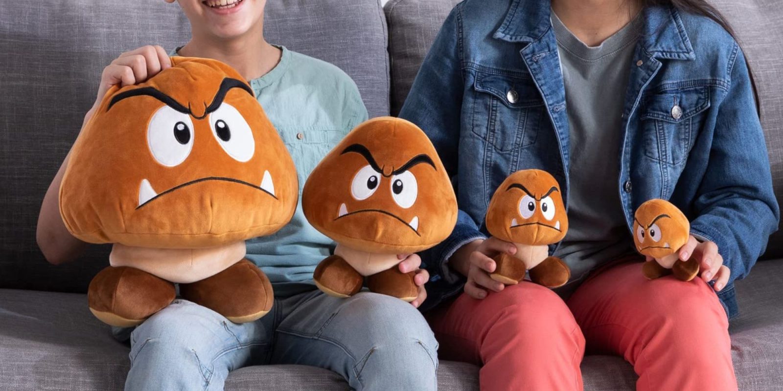 A group of people sitting on a couch holding stuffed animals.