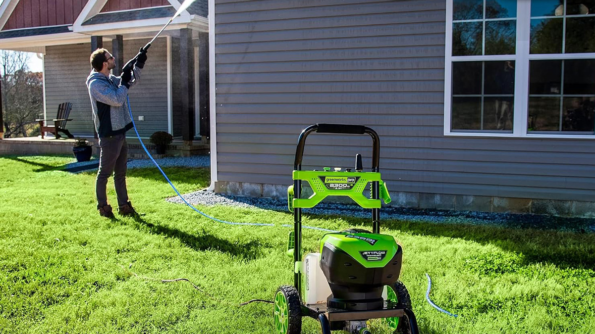 A person spraying a lawn with a hose