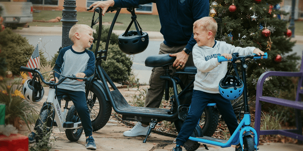 A group of kids with helmets and scooters