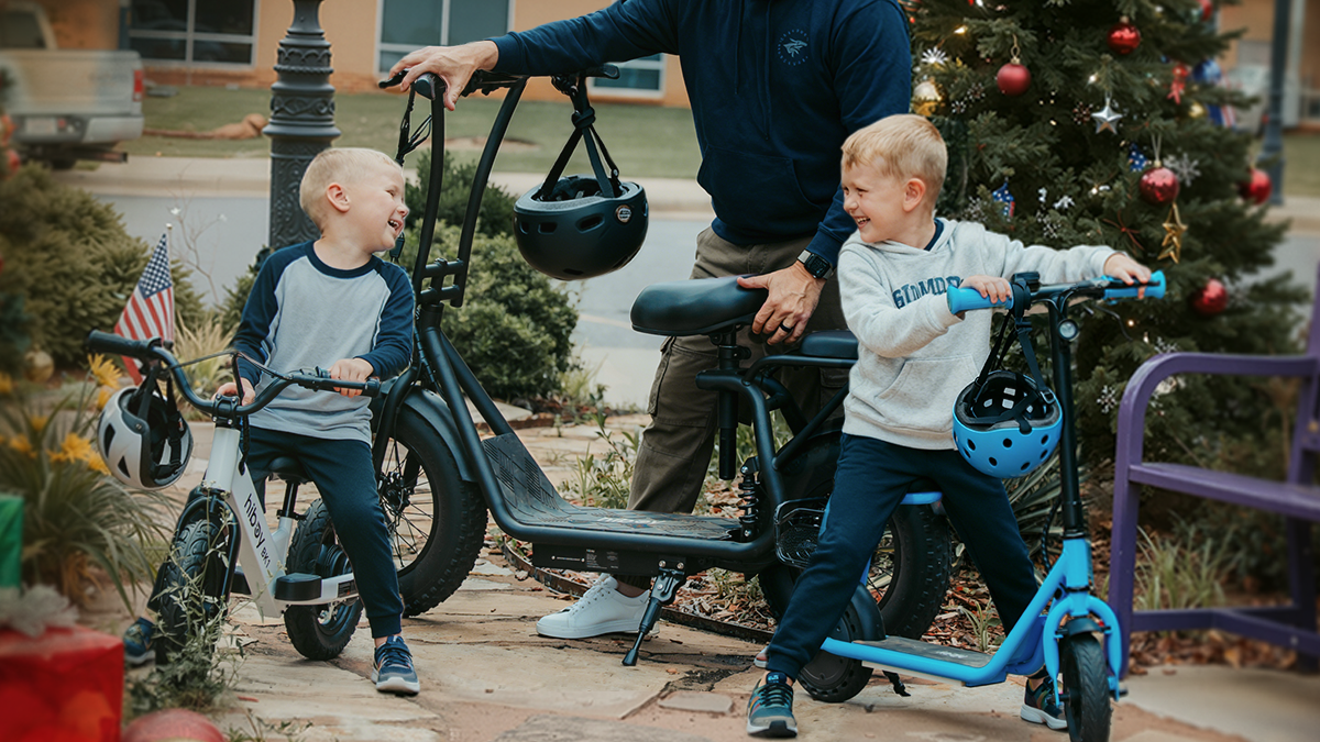 A group of kids with helmets and scooters