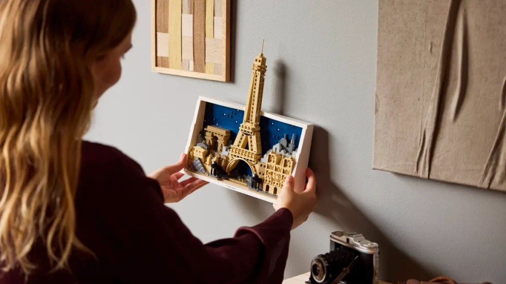 A woman holding a piece of lego