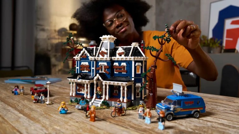 A woman playing with a toy house
