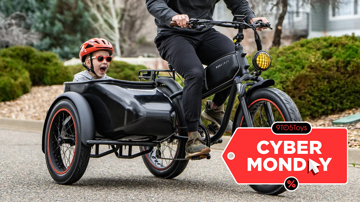 A man riding a bike with a child in a sidecar