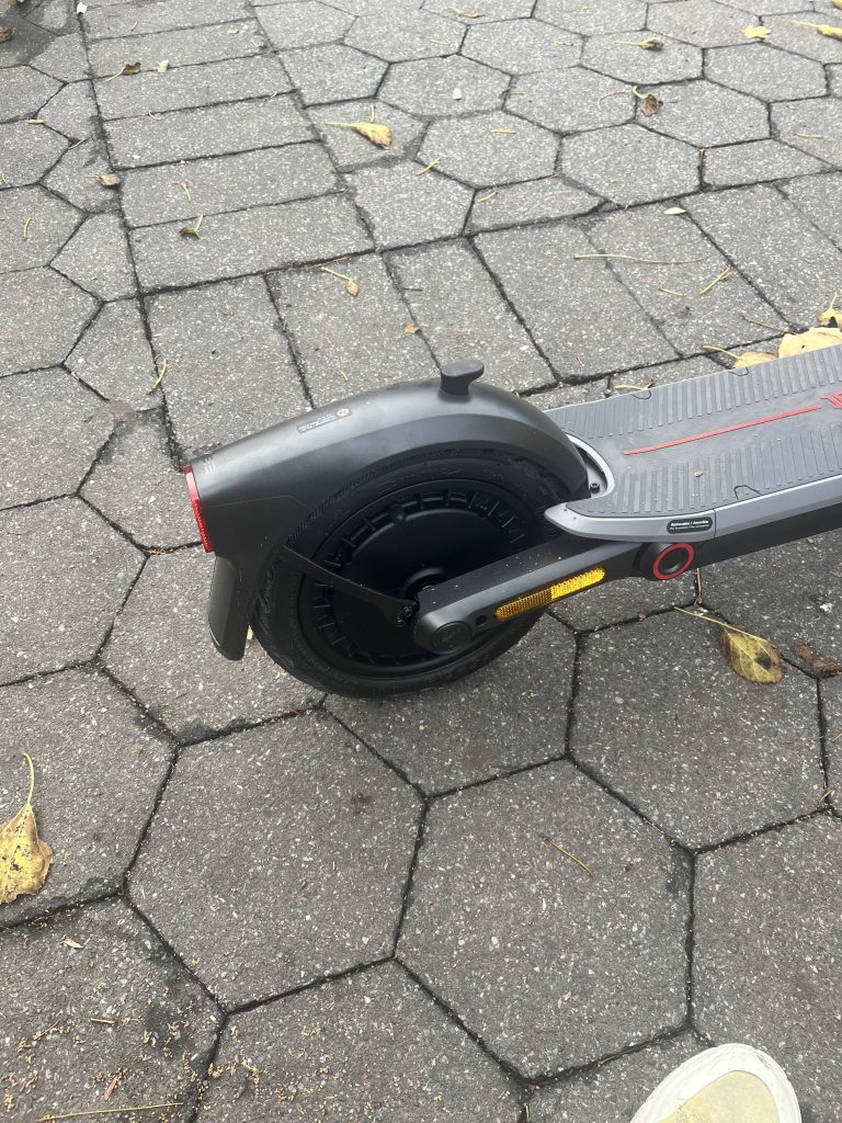 A black scooter on a brick surface