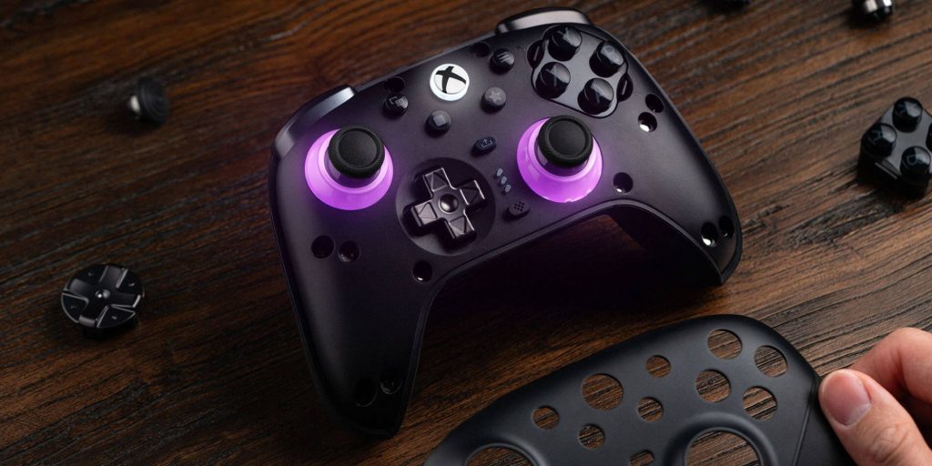 A black video game controller with purple lights