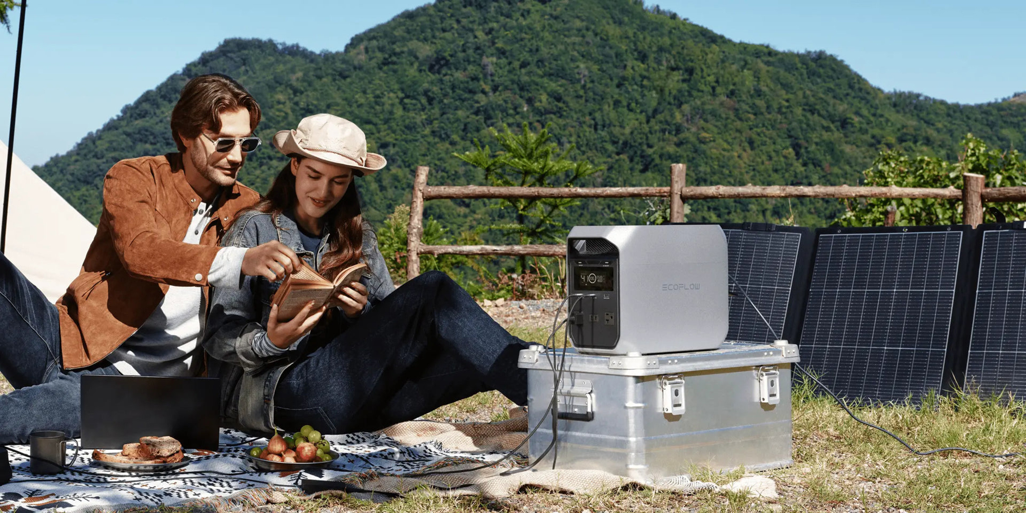 A woman sitting on a blanket reading a book
