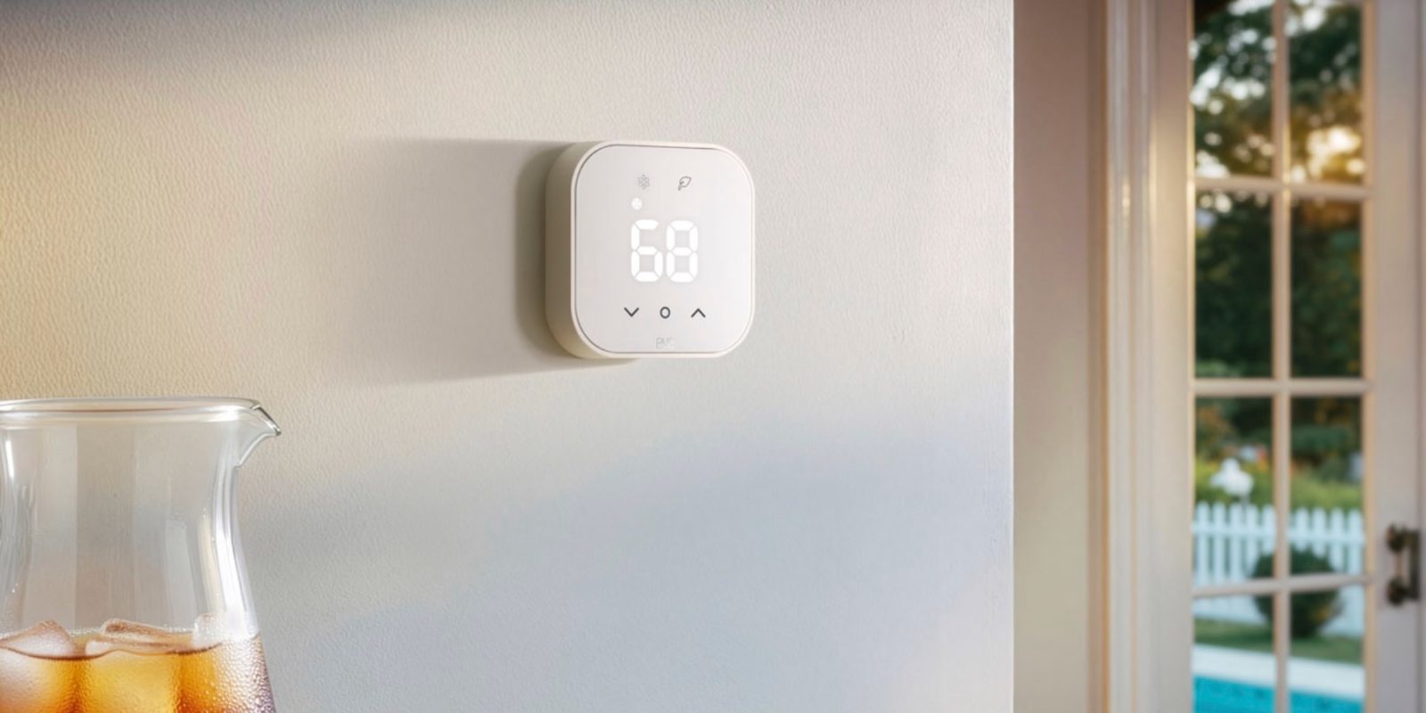 A white square device with a digital display on a white wall