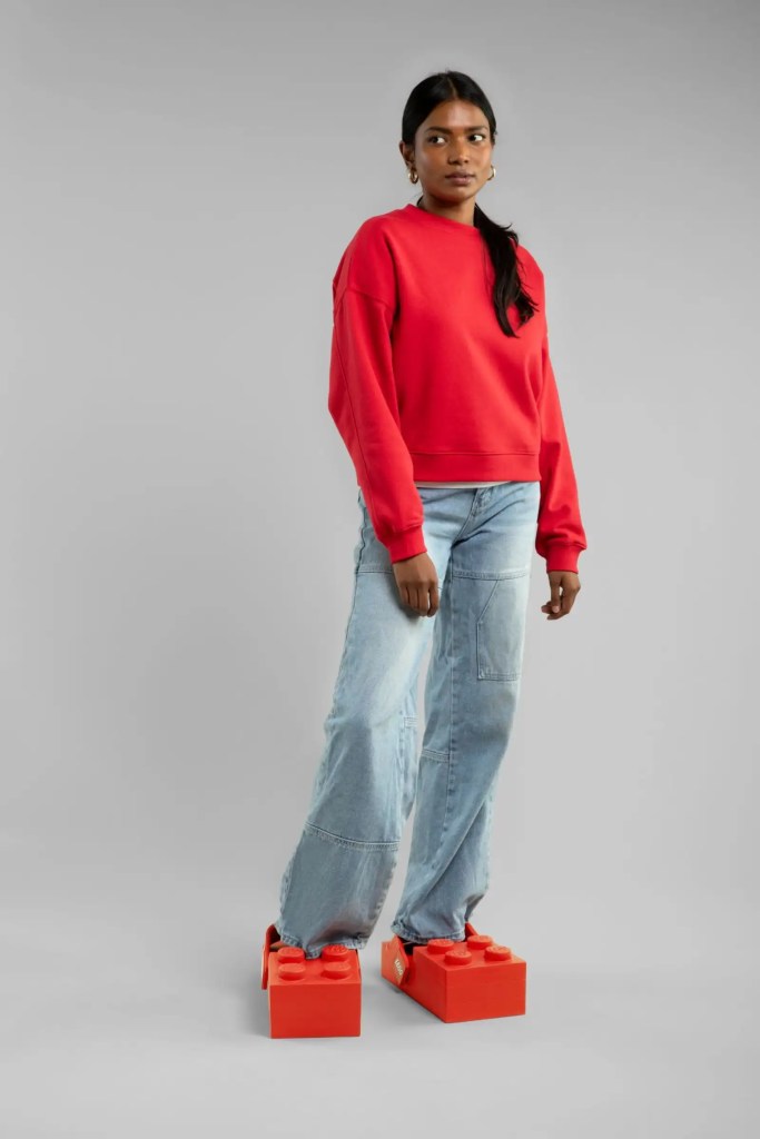 A woman in a red sweater and jeans