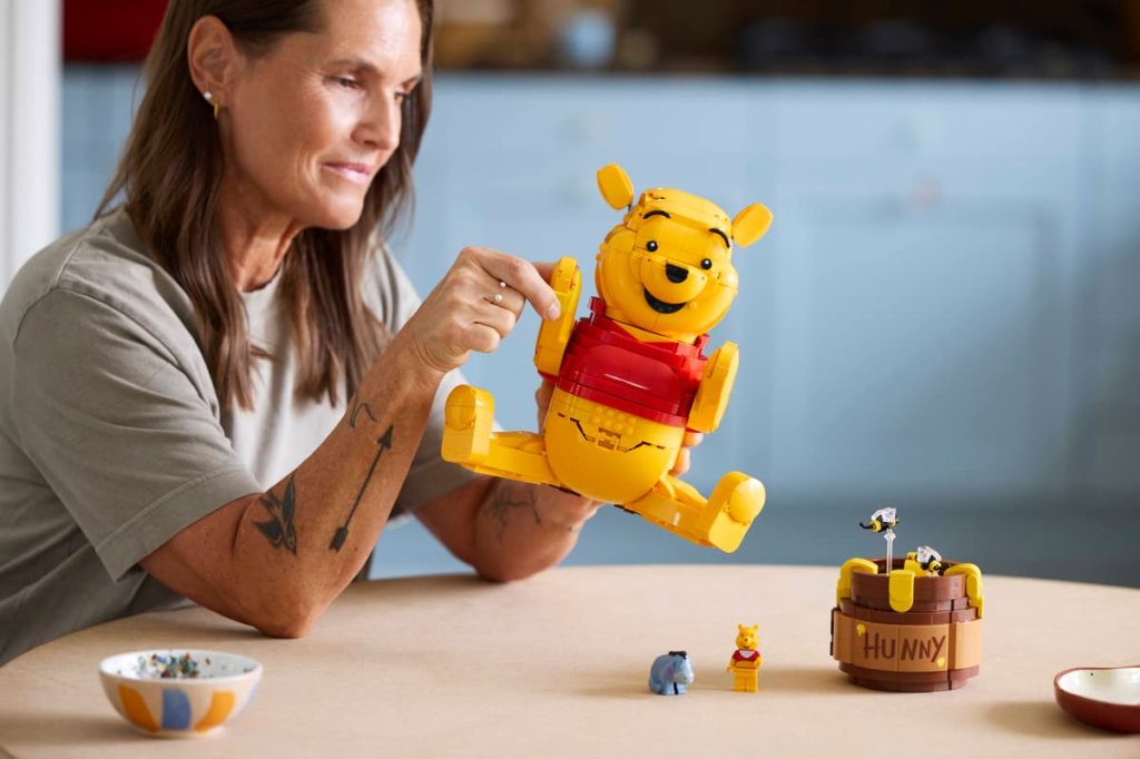 A woman playing with LEGO Winnie the Pooh