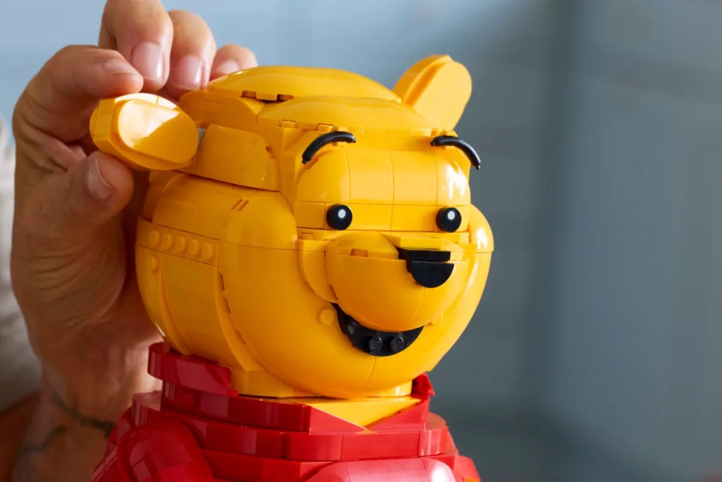 A person holding a LEGO Winnie the Pooh