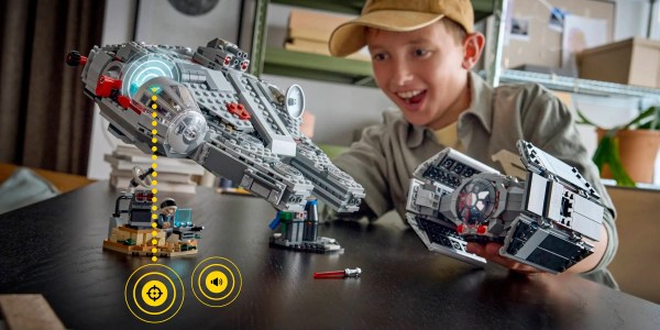 A boy sitting at a table with a toy spaceship