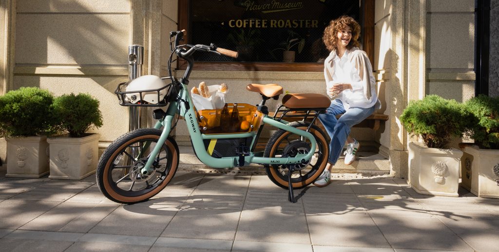 A woman sitting on a bench next to a bike
