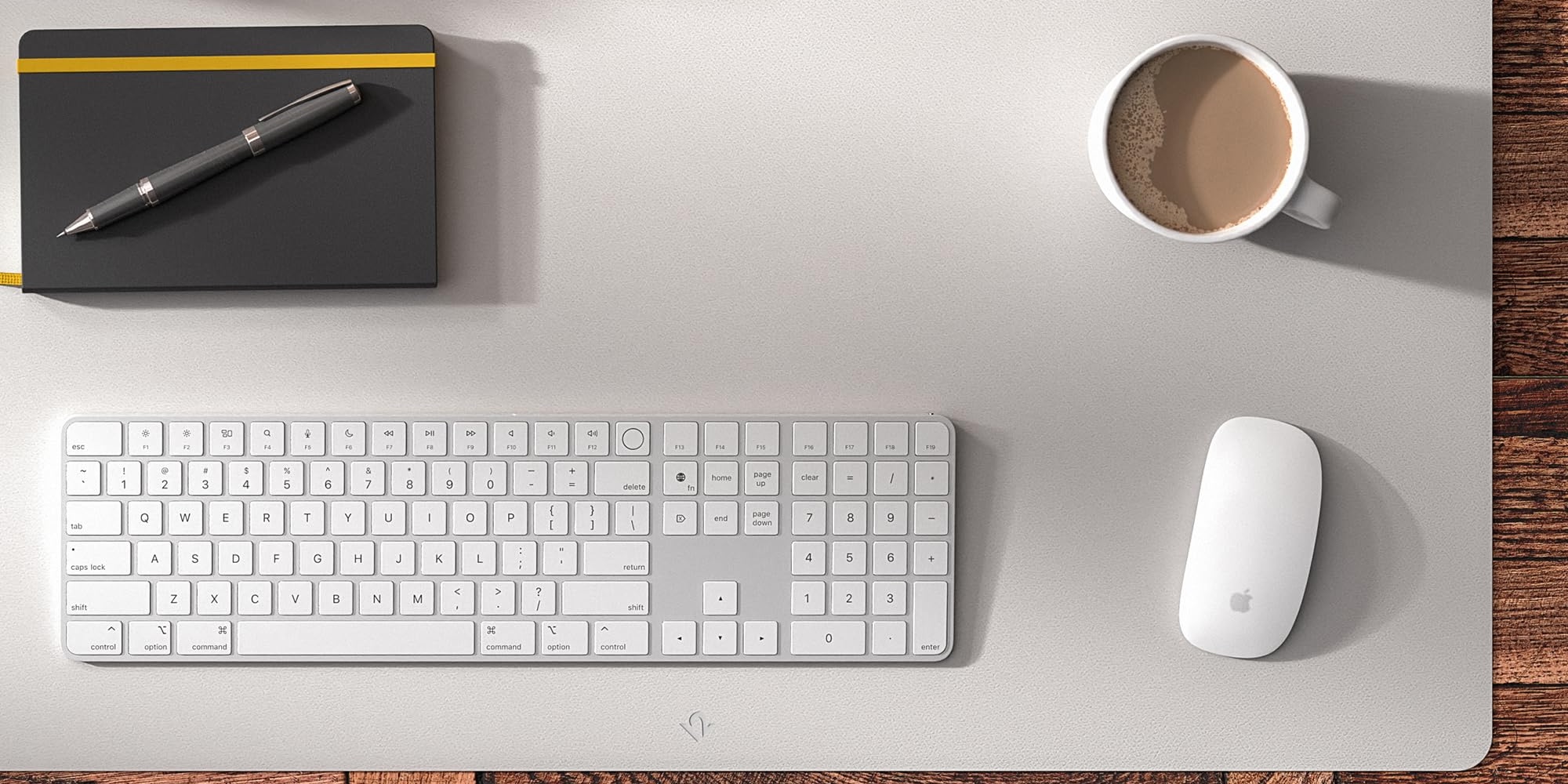 A keyboard and a cup of coffee on a desk