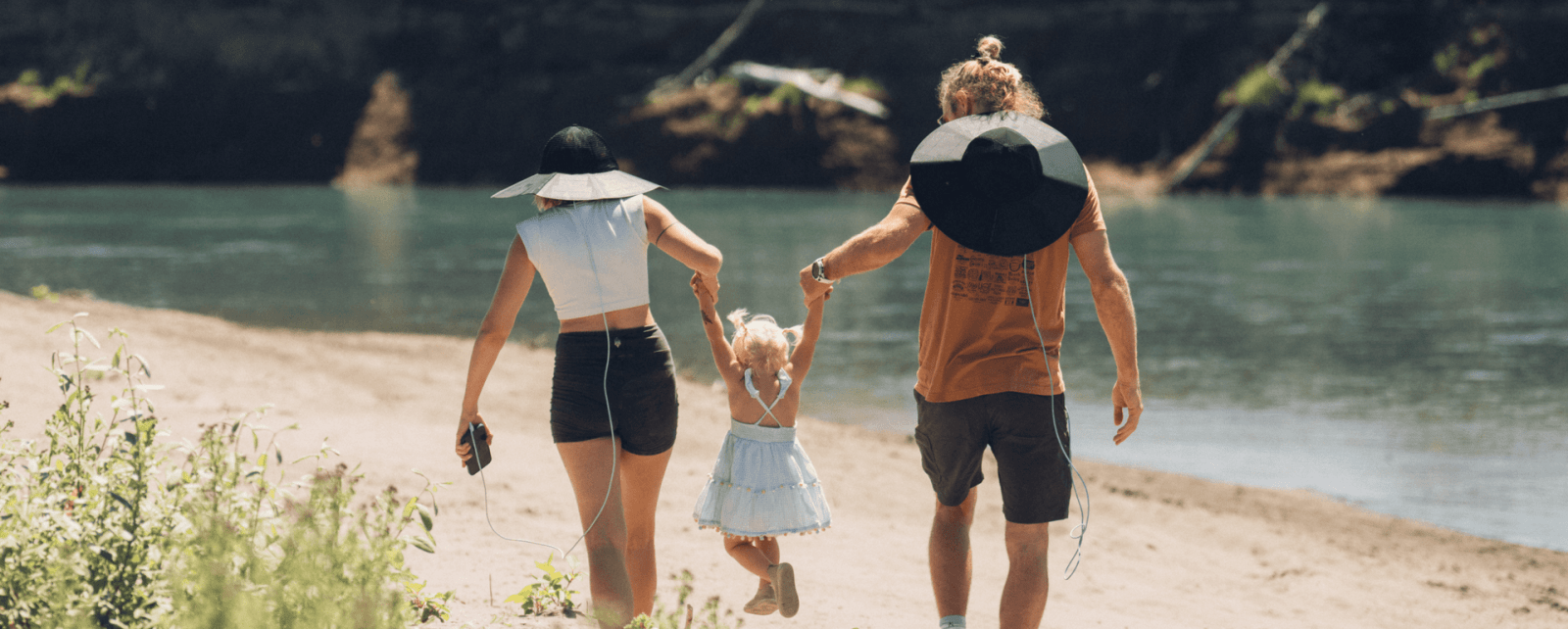 A group of people holding hands and walking on a beach